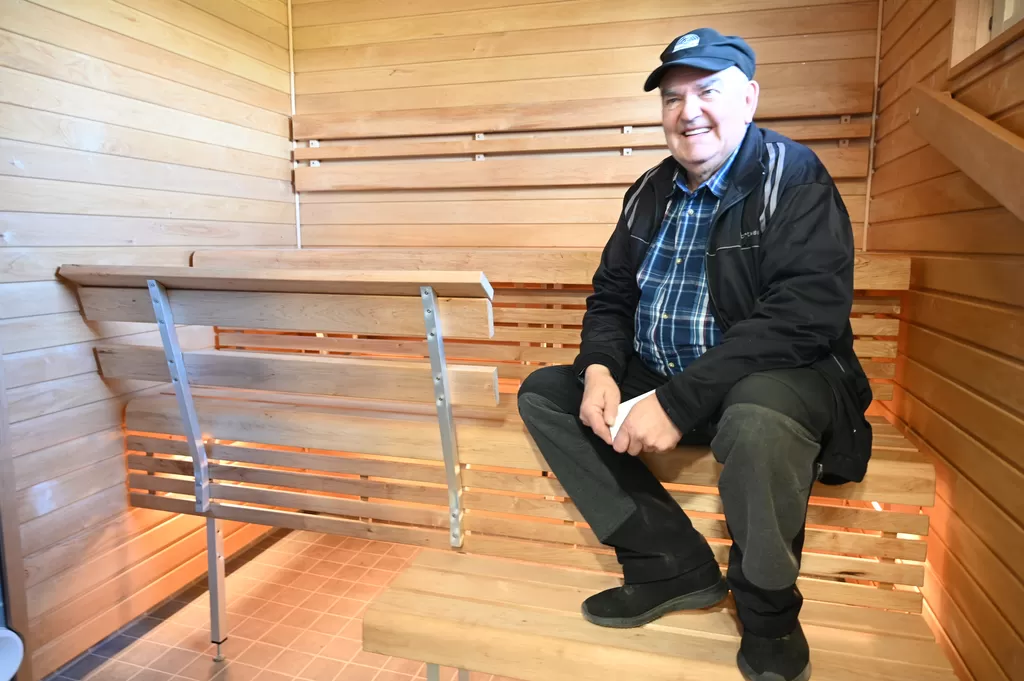 Vanhustentaloyhdistyksen puheenjohtaja Pertti Oksanen kipusi uusitun saunan lauteille.