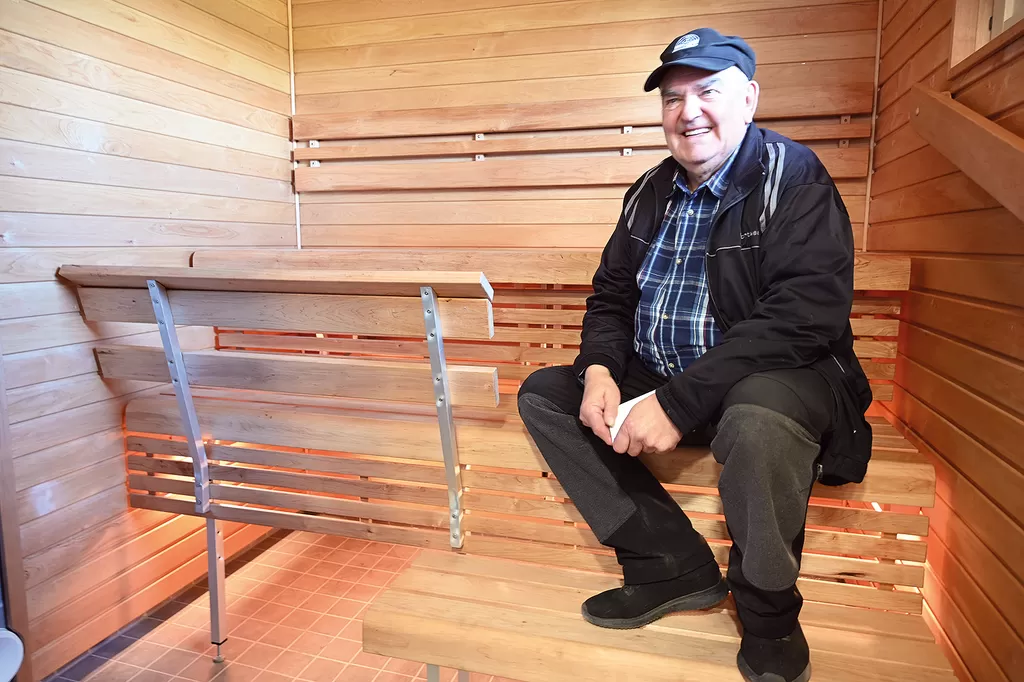 Vanhustentaloyhdistyksen puheenjohtaja Pertti Oksanen kipusi uusitun saunan lauteille.