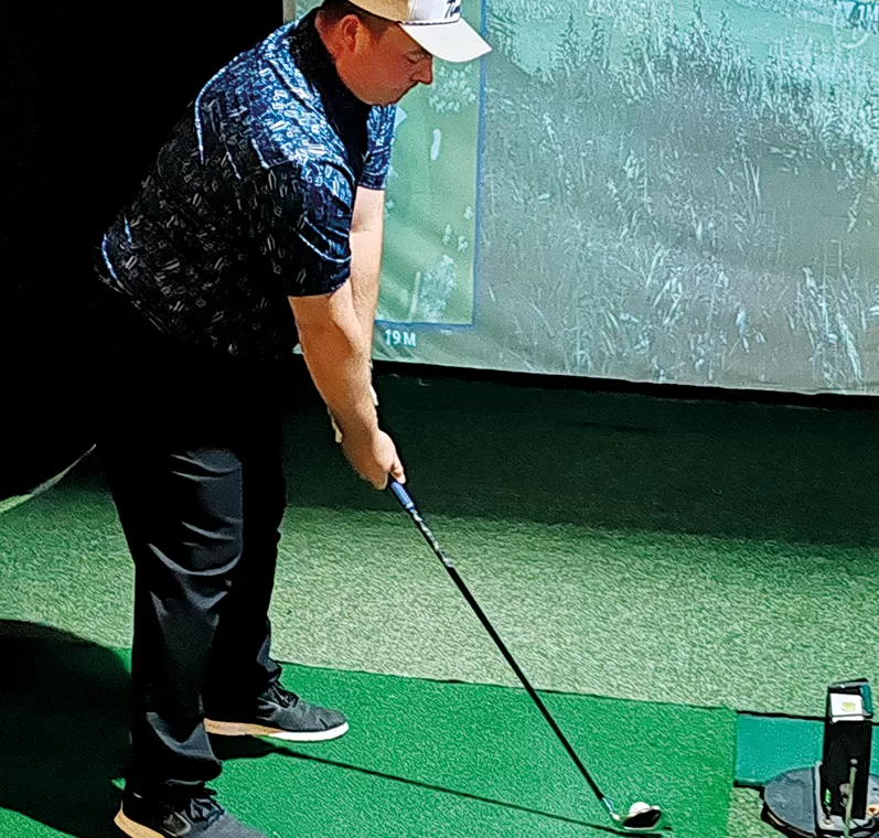 Sisäradan reikäpelin voittaneen Jani Pöppösen lyönnin lähtöasento golfsimulaattorissa Kehräämöllä.