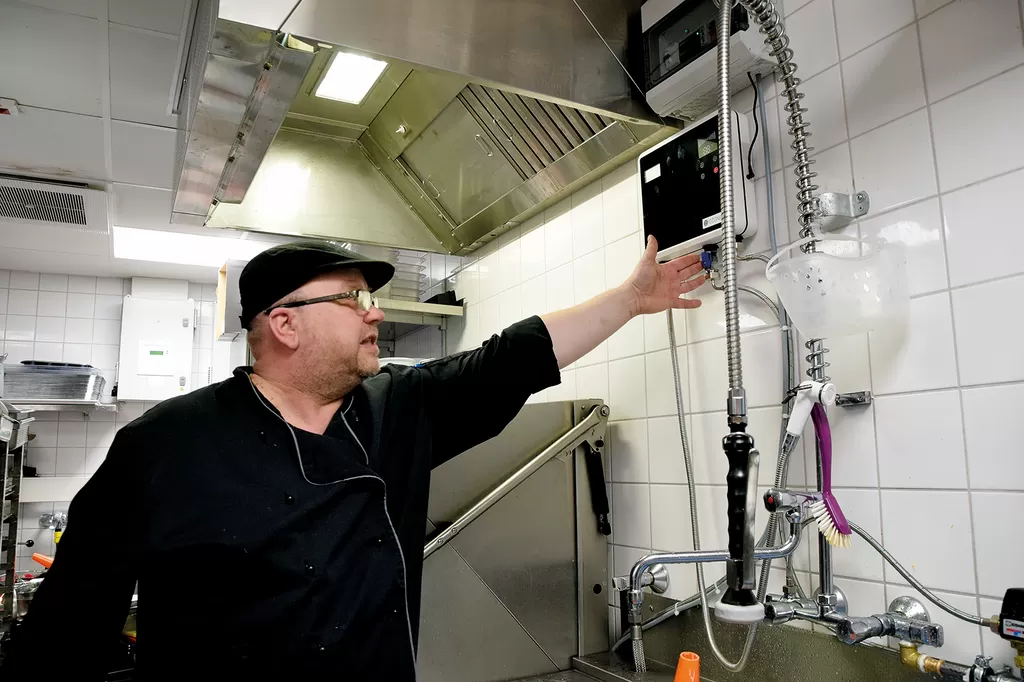Ravintola Tehtaan Kari Välimäki säätelee otsonointilaitteen asetuksia seinällä olevasta näytöstä.